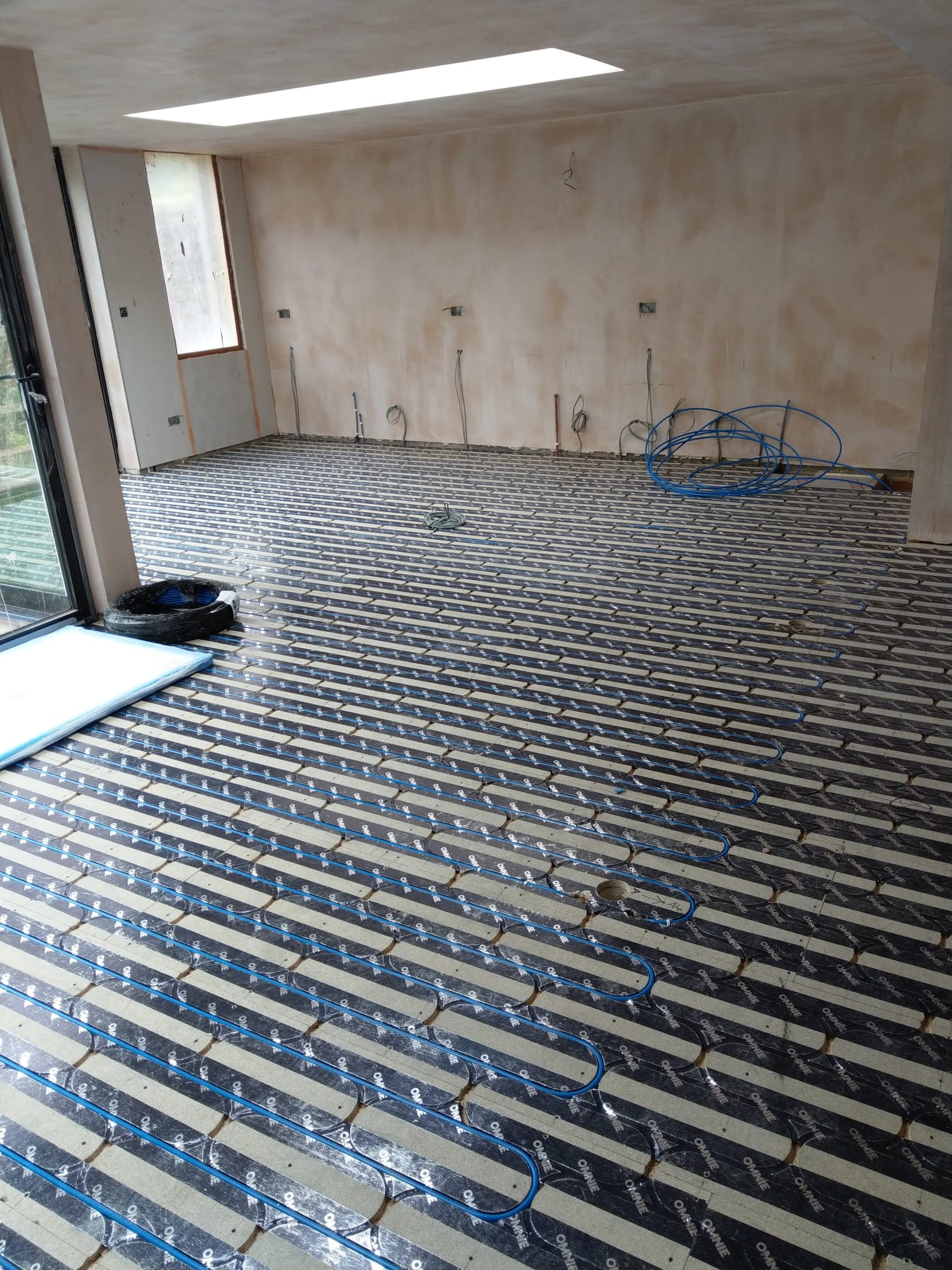Underfloor heating pipework being laid in screed